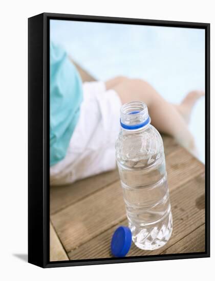 Child Sitting Beside Bottle of Water on Edge of Pool-null-Framed Stretched Canvas