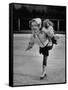 Child Skater Helen Ann Rousselle Holding Doll While Skating across the Ice-null-Framed Stretched Canvas