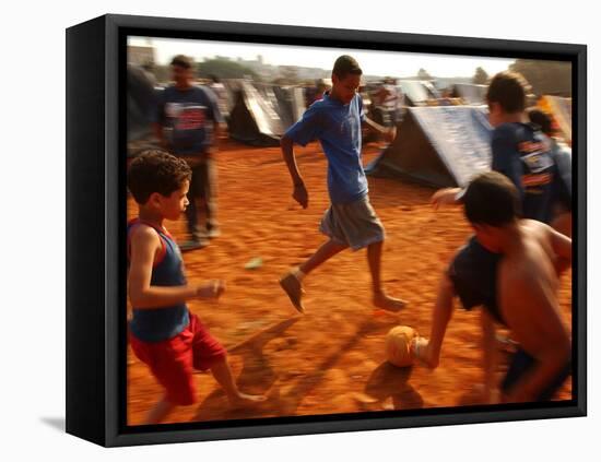 Children Play Soccer Between Tents Placed on a Dusty Lot-null-Framed Stretched Canvas