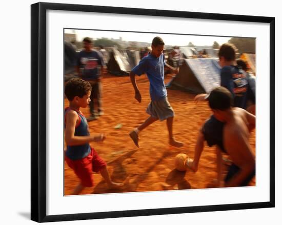 Children Play Soccer Between Tents Placed on a Dusty Lot-null-Framed Photographic Print