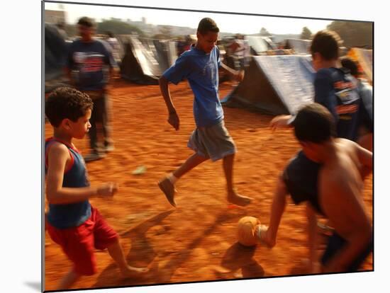 Children Play Soccer Between Tents Placed on a Dusty Lot-null-Mounted Photographic Print