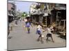 Children Play Soccer on One of the Streets of the Business District of Lagos-null-Mounted Premium Photographic Print