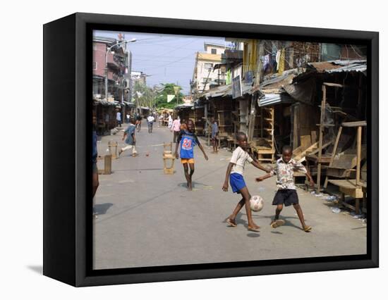 Children Play Soccer on One of the Streets of the Business District of Lagos-null-Framed Stretched Canvas