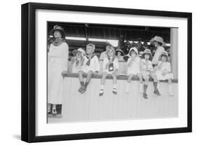 Children Sit on Wall in Front of Stands at the Ballpark and Eat Ice Cream Cones.-null-Framed Art Print