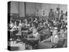 Children Sitting at their Desks in a Classroom, Teachers at the Rear of the Room-null-Stretched Canvas