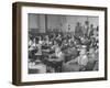 Children Sitting at their Desks in a Classroom, Teachers at the Rear of the Room-null-Framed Photographic Print