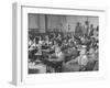 Children Sitting at their Desks in a Classroom, Teachers at the Rear of the Room-null-Framed Photographic Print