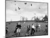 Children Trying to Catch Toys That Were Released by a Kite in the Air-Bernard Hoffman-Mounted Photographic Print