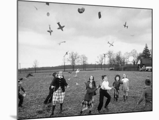 Children Trying to Catch Toys That Were Released by a Kite in the Air-Bernard Hoffman-Mounted Photographic Print