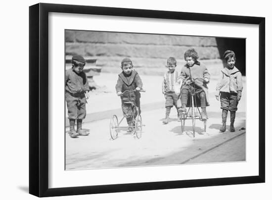 Children With Tricycles Playing In Manhattan Street-null-Framed Art Print