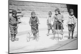 Children With Tricycles Playing In Manhattan Street-null-Mounted Art Print