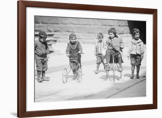 Children With Tricycles Playing In Manhattan Street-null-Framed Premium Giclee Print