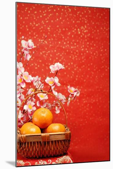 Chinese New Year Decoration--A Basket of Oranges with Plum Flower on a Festive Background.-Liang Zhang-Mounted Photographic Print