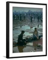 Chuck Morgan Sitting in the Mud and Water with a Friend, During Woodstock Music and Art Fair-John Dominis-Framed Photographic Print