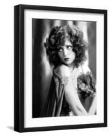 circa, 1929: Hollywood film star, Clara Bow (1905 - 1965) poses in a cape with jewelled clasp (b/w-null-Framed Photo