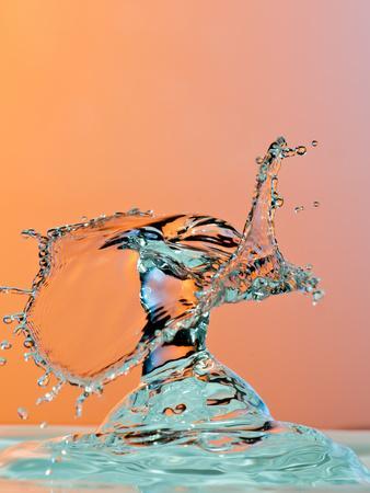Dancing Water Droplet High Speed Photography on an Orange Background