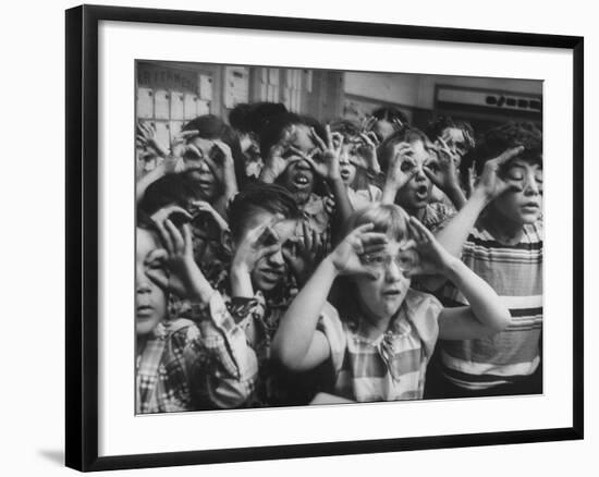 Classroom Full of Students Circling Fingers Around Eyes in Form of Glasses During Music Class-Francis Miller-Framed Photographic Print