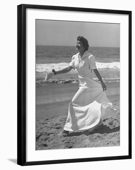 Claudette Colbert in Zippered, Terry Cloth Beach Robe, Sashaying Along Surf at Santa Monica Beach-Peter Stackpole-Framed Premium Photographic Print