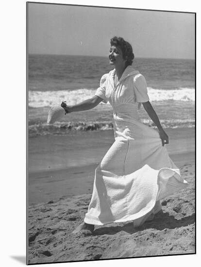 Claudette Colbert in Zippered, Terry Cloth Beach Robe, Sashaying Along Surf at Santa Monica Beach-Peter Stackpole-Mounted Premium Photographic Print