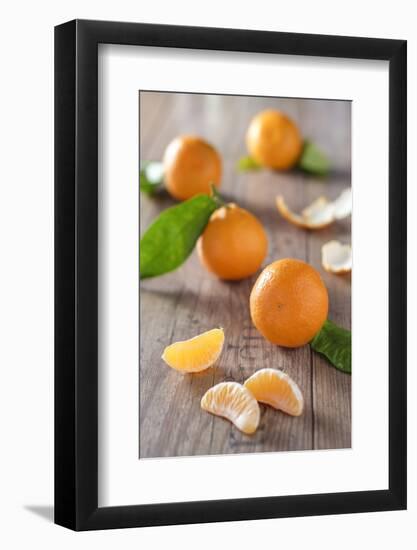 Clementines with Foliage, Pieces of Clementines and Peel on a Wooden Table-Jana Ihle-Framed Photographic Print