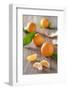 Clementines with Foliage, Pieces of Clementines and Peel on a Wooden Table-Jana Ihle-Framed Photographic Print