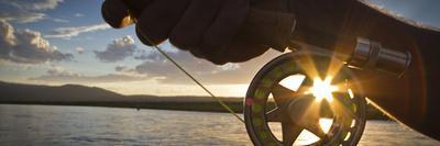 A Sunset Sunstart Through the Fly Reel of an Angler on the Henry's Fork River in Idaho.-Clint Losee-Photographic Print