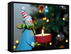 Close-Up of a Snow Man Candle in Front of a Tree with Christmas Lights-Winfred Evers-Framed Stretched Canvas