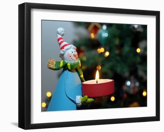 Close-Up of a Snow Man Candle in Front of a Tree with Christmas Lights-Winfred Evers-Framed Premium Photographic Print