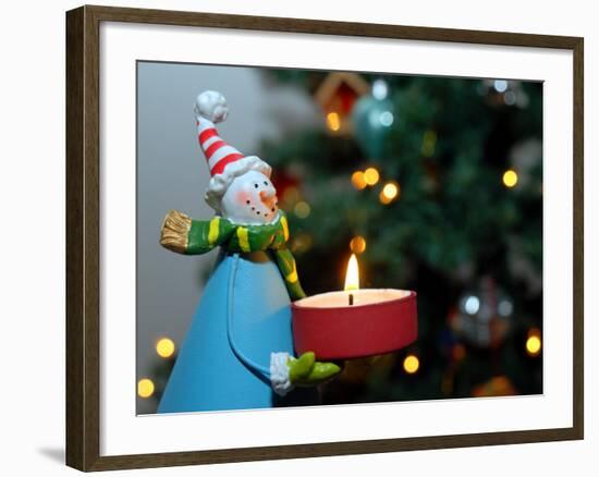 Close-Up of a Snow Man Candle in Front of a Tree with Christmas Lights-Winfred Evers-Framed Photographic Print