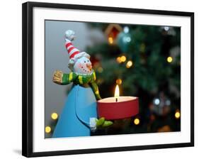 Close-Up of a Snow Man Candle in Front of a Tree with Christmas Lights-Winfred Evers-Framed Photographic Print