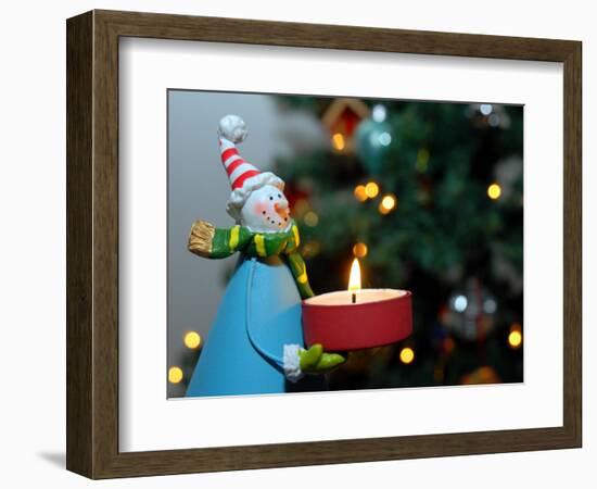 Close-Up of a Snow Man Candle in Front of a Tree with Christmas Lights-Winfred Evers-Framed Photographic Print