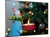 Close-Up of a Snow Man Candle in Front of a Tree with Christmas Lights-Winfred Evers-Mounted Photographic Print