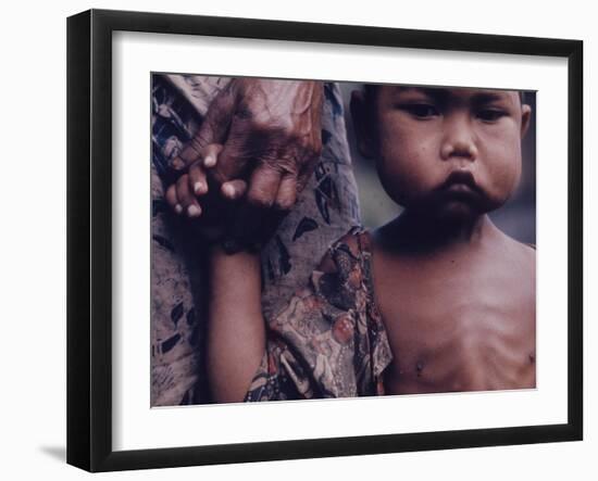 Close-Up of an Indonesian Child Holding on to the Hand of His Mother-Co Rentmeester-Framed Photographic Print