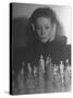 Close Up of Danielle Darrieux Looking at Chess Pieces-David Scherman-Stretched Canvas