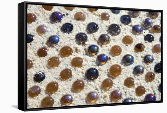 Close up of glass marbles in sand-John Gollings-Framed Stretched Canvas