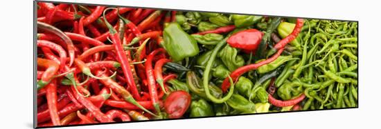 Close-Up of Green and Red Chili Peppers at Market Stall-null-Mounted Photographic Print