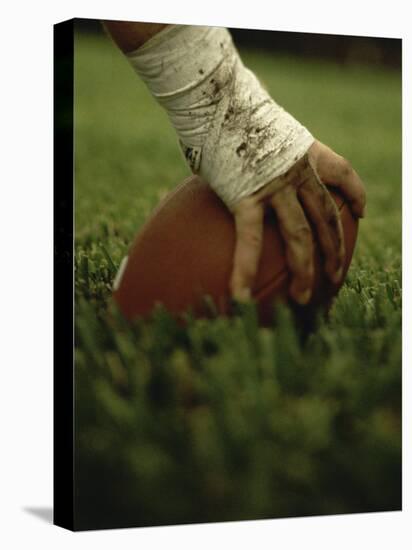 Close-up of the Hand of an American Football Player Holding a Football-null-Stretched Canvas