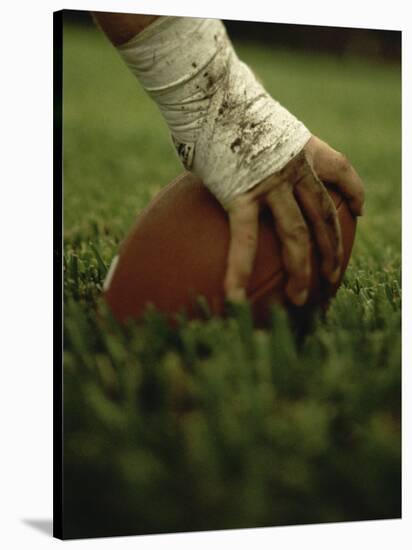 Close-up of the Hand of an American Football Player Holding a Football-null-Stretched Canvas