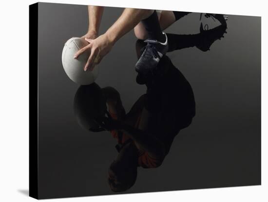 Closeup Low Section and Reflection of a Rugby Player Kneeling on One Knee with Ball-Nosnibor137-Stretched Canvas