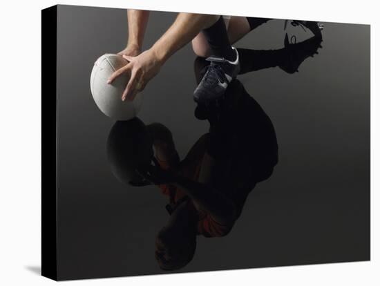 Closeup Low Section and Reflection of a Rugby Player Kneeling on One Knee with Ball-Nosnibor137-Stretched Canvas