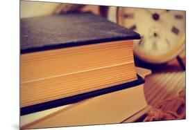 Closeup of a Pile of Old Books and an Old Alarm Clock on a Desk, with a Retro Effect-nito-Mounted Photographic Print