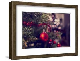 Closeup of Red Bauble Hanging from a Decorated Christmas Tree. Retro Filter Effect.-Gajus-Framed Photographic Print