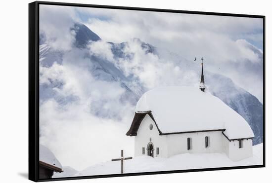 Clouds Above the Mountain Huts and Church Covered with Snow, Bettmeralp, District of Raron-Roberto Moiola-Framed Stretched Canvas