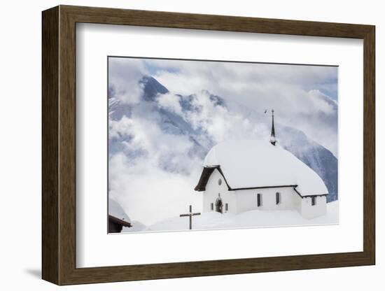 Clouds Above the Mountain Huts and Church Covered with Snow, Bettmeralp, District of Raron-Roberto Moiola-Framed Photographic Print