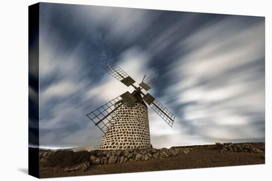 Clouds in the starry sky over a traditional windmill, La Oliva, Fuerteventura, Canary Islands-Roberto Moiola-Stretched Canvas