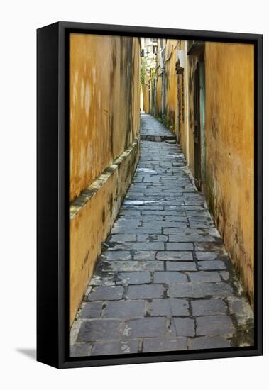 Cobblestones and yellow walls in alleyway, Hoi An, Vietnam-David Wall-Framed Stretched Canvas