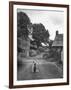 Collie Sheepdog Sitting in Road Leading Up Toward Castle Farm Owned by Beatrix Potter-George Rodger-Framed Photographic Print