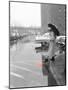 Color Pop,1950s WOMAN IN RAIN COAT HAT BOOTS HOLDING UMBRELLA CROSSING CITY STREET-null-Mounted Photographic Print