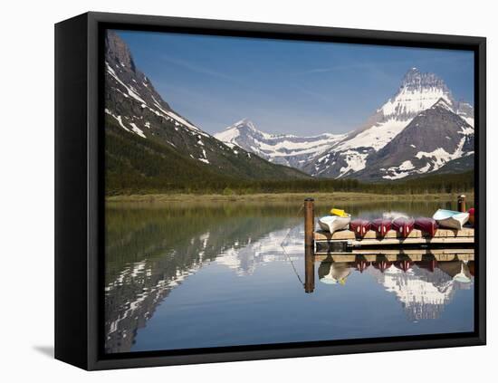 Colorful Canoes Line the Dock at Many Glacier Lodge on Swiftcurrent Lake During Sunrise-Brad Beck-Framed Stretched Canvas