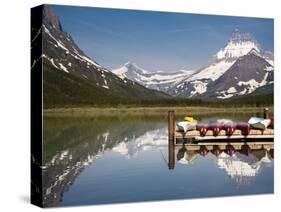 Colorful Canoes Line the Dock at Many Glacier Lodge on Swiftcurrent Lake During Sunrise-Brad Beck-Stretched Canvas